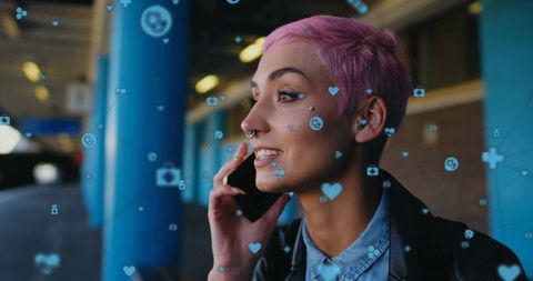 Young woman at train station using smartphone with digital network overlay