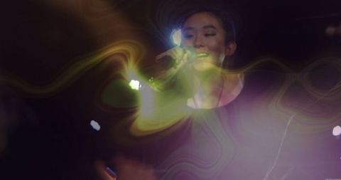 Ethereal performer on stage with dynamic lights and haze