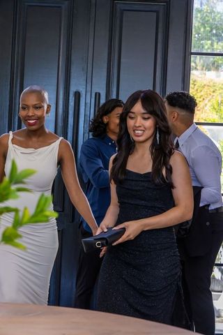 Guests mingling in eveningwear at elegant gala venue with diverse group
