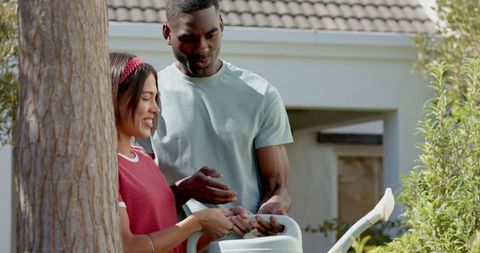 Diverse couple watering garden for timeless gardening moment