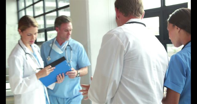 Medical Team Discussing Patient Treatment in Hospital Hallway - Download Free Stock Images Pikwizard.com