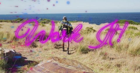 Backpacker walking coastal trail toward ocean with neon pink walk it motivational lettering