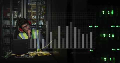It technician wearing hi-vis vest and ear protection testing servers with laptop analytics