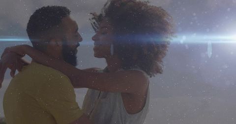 Romantic closeup of embracing young couple with lens flare, soft studio light, intimate portrait