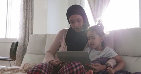 Mother and Daughter Using Tablet in Sunlit Living Room