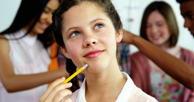 Thoughtful Girl Holding Pencil in Classroom - Download Free Stock Images Pikwizard.com