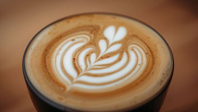 Ceramic Cup Latte with Rosetta Latte Art, Velvety Microfoam and Cinnamon Specks Closeup