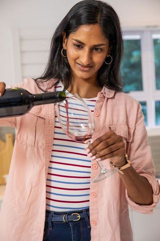Indian Woman Pouring Red Wine in Home Setting