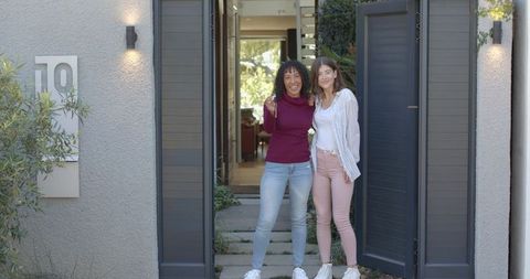 Happy Friends Holding New House Keys at Modern Front Door