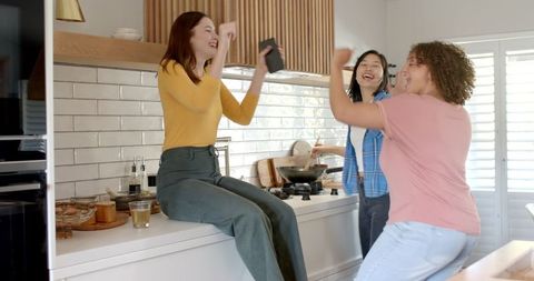 Diverse Female Friends Joyfully Celebrating in Modern Kitchen