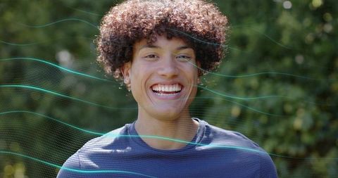 Smiling young man wearing navy shirt and stud earrings facing camera with teal overlay