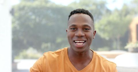 Smiling african american man video calling outdoors