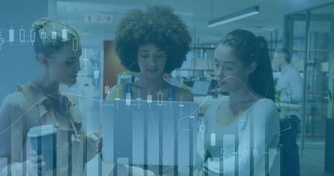 Women collaborating on technology project in modern library