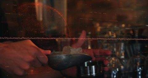 Bartender scooping ice cubes into mixing tin for craft cocktails