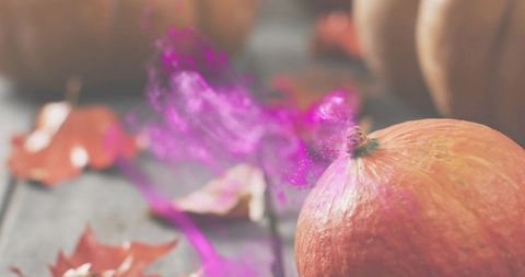 Autumn pumpkin glowing in warm light with purple mist swirling on rustic wooden table