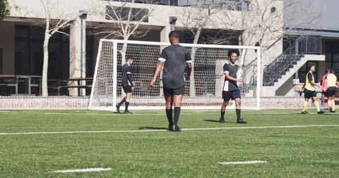Soccer Team Strategizing During Outdoor Practice on Sunny Field