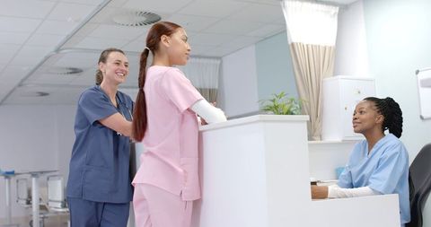 Diverse Healthcare Professionals Conversing at Reception Desk - Download Free Stock Images Pikwizard.com
