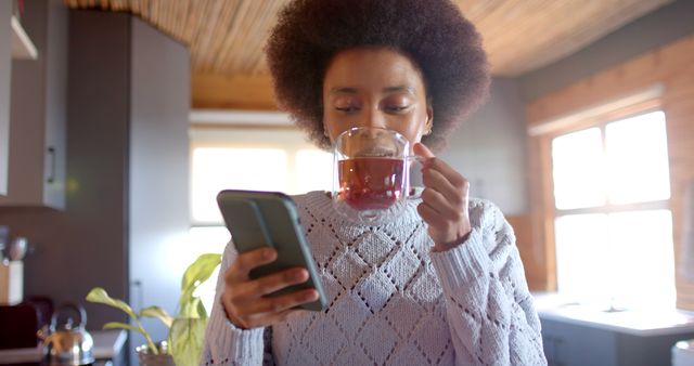 Young Woman Enjoying Hot Beverage while Using Smartphone at Home - Download Free Stock Images Pikwizard.com