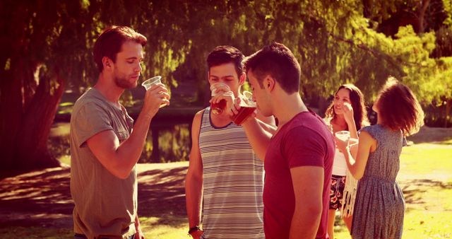 Young Adults Enjoying Outdoor Drinks in Summer Park - Download Free Stock Images Pikwizard.com