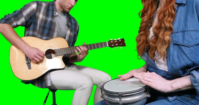 Musicians playing guitar and drum against green screen