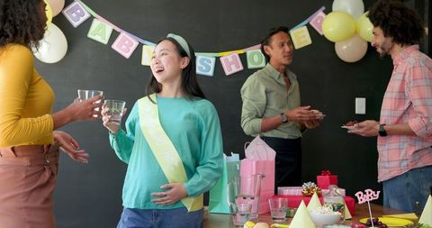 Multiracial colleagues celebrating office baby shower