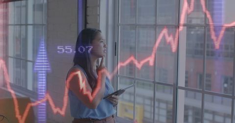Businesswoman analyzing stock market trends in modern office