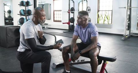 Personal Trainer Discussing Workout with Client in Gym