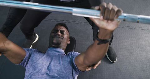 Man bench pressing barbell during strength training