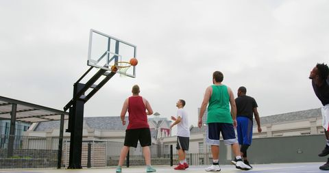 Diverse Male Basketball Players Competing on Outdoor Court
