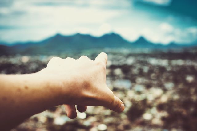 Hand Pointing Toward Distant Mountains Across Blurred Cityscape - Download Free Stock Images Pikwizard.com