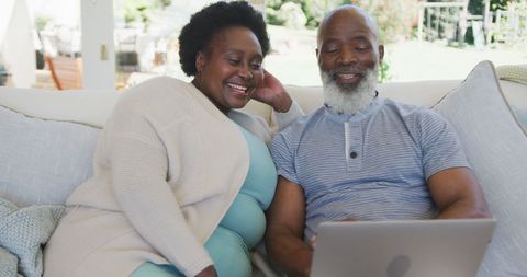 Happy Senior Couple Video Calling at Home Through Laptop