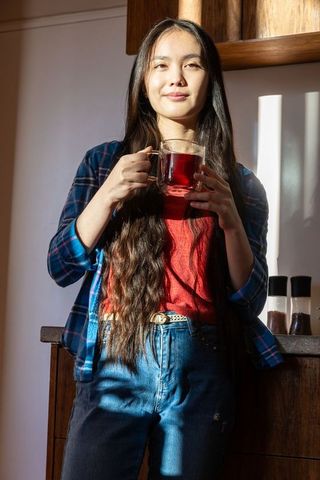 Woman Relaxing with Herbal Tea in Cozy Kitchen Space