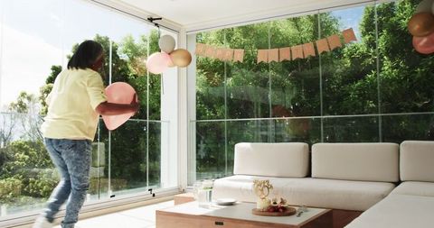 Senior couple decorating for birthday celebration in sunroom