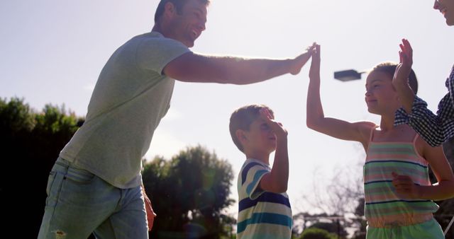 Happy Family High-Fiving During Outdoor Playtime - Download Free Stock Images Pikwizard.com