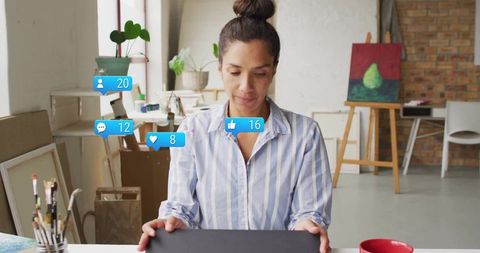 Woman engaging with social media in artistic studio environment