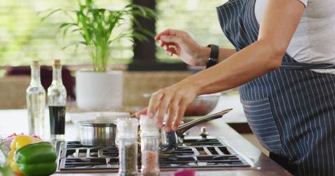 Pregnant Woman Using Smartphone While Cooking in Kitchen at Home