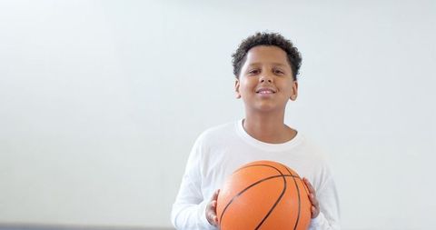 Confident Boy Holding Basketball Ready for Game