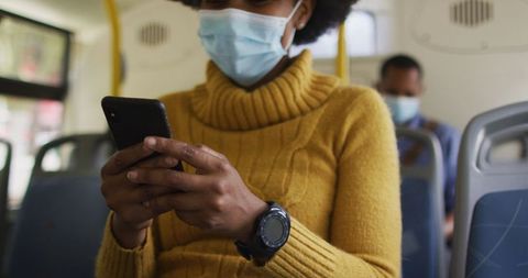 Woman Using Smartphone on Public Bus During COVID-19 Pandemic