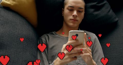 Young Man Using Smartphone with Floating Digital Hearts