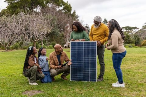 African american multigenerational family inspecting solar panel outdoors, learning solar energy