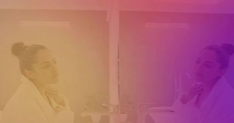 Woman in bathrobe contemplating reflection in mirror with colorful hue