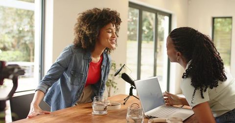 Two Black Women Recording Podcast and Collaborating Over Laptop and Microphone Cozy Home