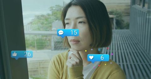 Woman reflecting on social media notifications on balcony