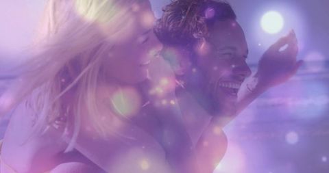 Romantic Couple Enjoying Piggyback Ride on Luminous Beach