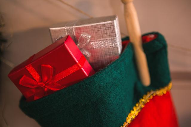 Close-up of christmas stockings hanging on fireplace with gifts