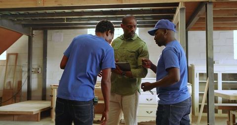 Team Discussing Woodwork Quality in Modern Workshop