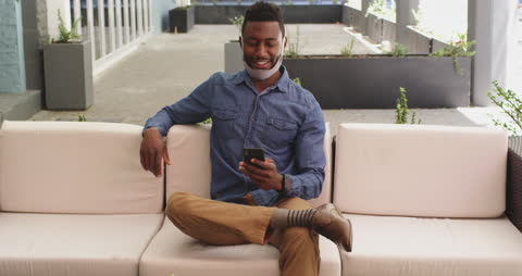 Man Relaxing in Outdoor Cafe Using Smartphone with Mask