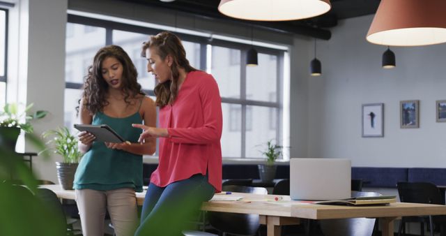 Two Women Collaborating on Digital Tablet in Modern Office Space - Download Free Stock Images Pikwizard.com