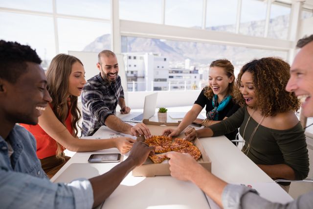 Group of diverse colleagues sharing pizza in a modern conference room. Ideal for illustrating teamwork, office culture, casual meetings, and corporate lunch breaks. Perfect for business blogs, company websites, and promotional materials highlighting a positive work environment.