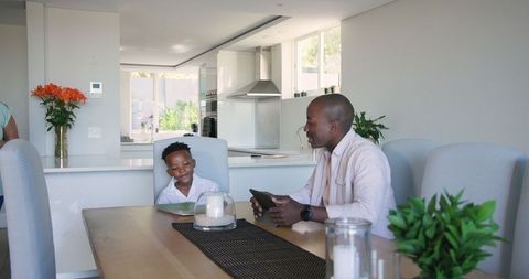 Smiling Father and Son Enjoy Breakfast in Modern Kitchen Setting